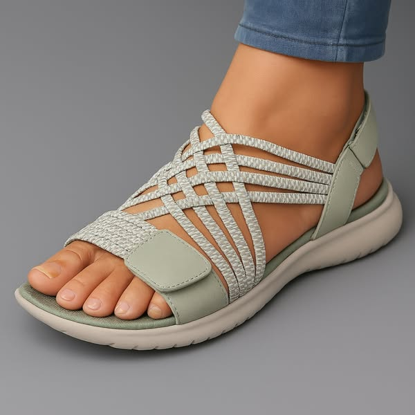 Lifestyle shot of a woman wearing green walking sandals, walking on a paved path, demonstrating their everyday comfort.