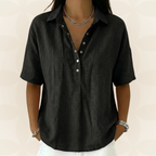 Woman enjoying a sunny day in a black V-neck shirt, looking effortlessly stylish and at ease.