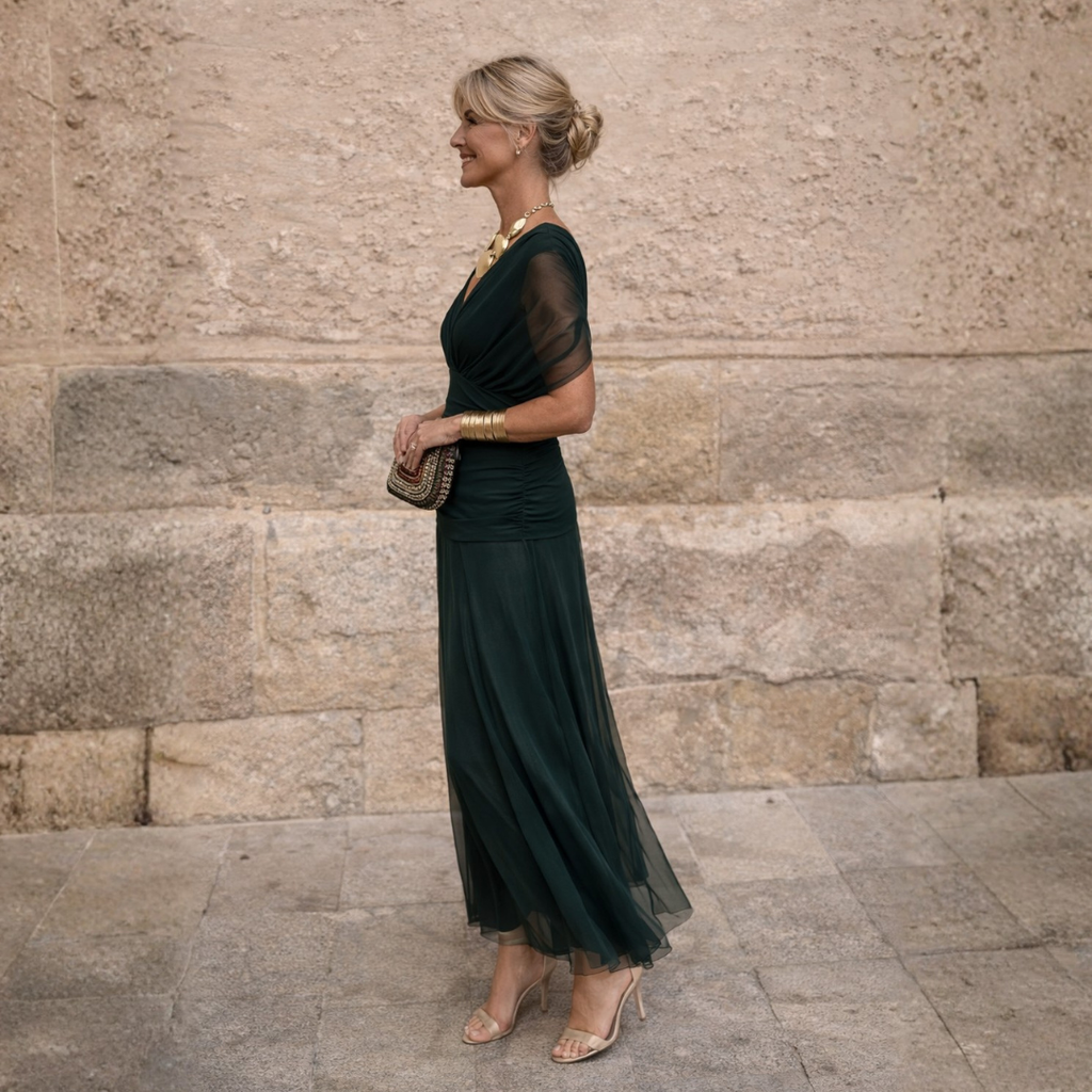 Side profile of the sculpted off-shoulder maxi dress, highlighting the flattering mermaid silhouette.