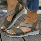 Side profile of black orthopedic sandals on a neutral background, highlighting the ergonomic insole and heel support.