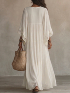 Close-up detail of the white lace trim on the deep V-neck and batwing sleeve of the elegant batwing dress.