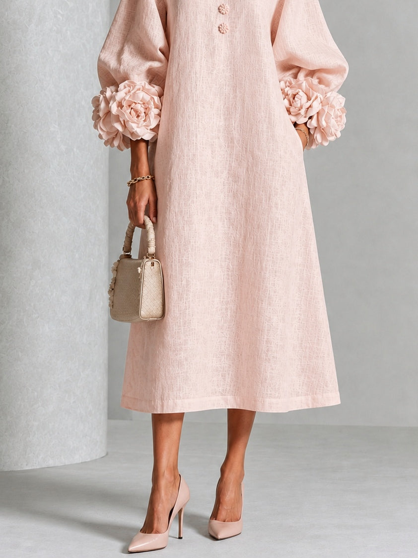 Detailed shot of the exaggerated rose-knot cuffs on the voluminous three-quarter sleeves of the dress.