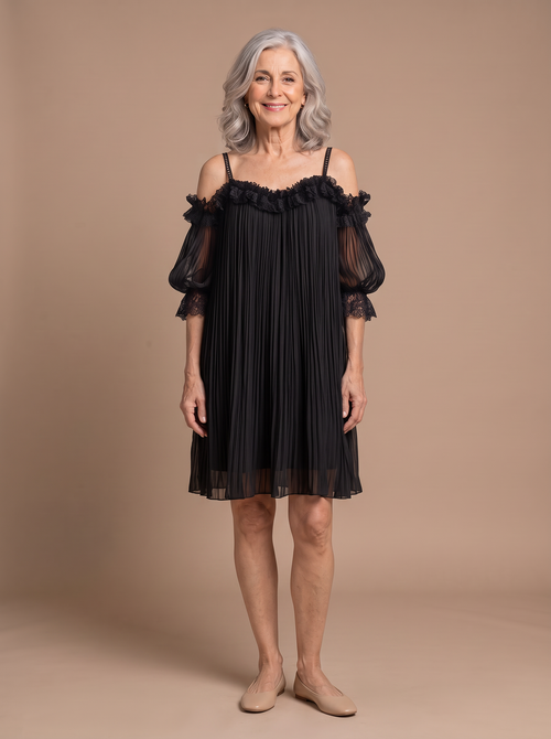 Anya - Elegant Muslin Mini Dress, model draagt de zwarte jurk op warme beige studio-achtergrond